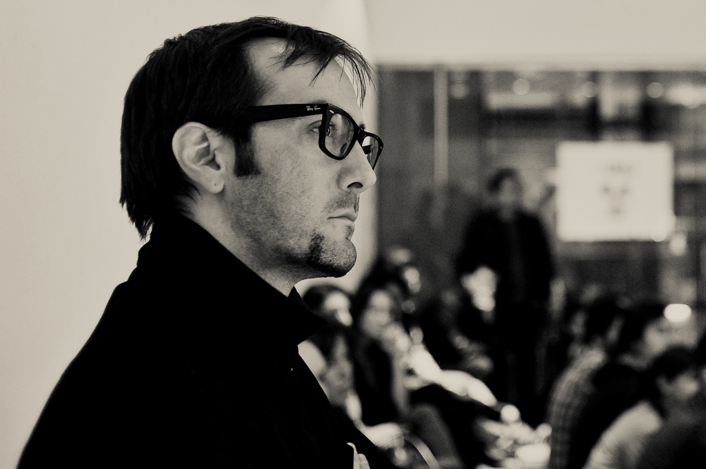 Man with glasses listening to speaker at design talk