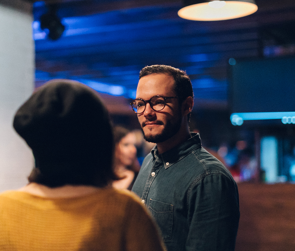Man with glasses listening to conversation