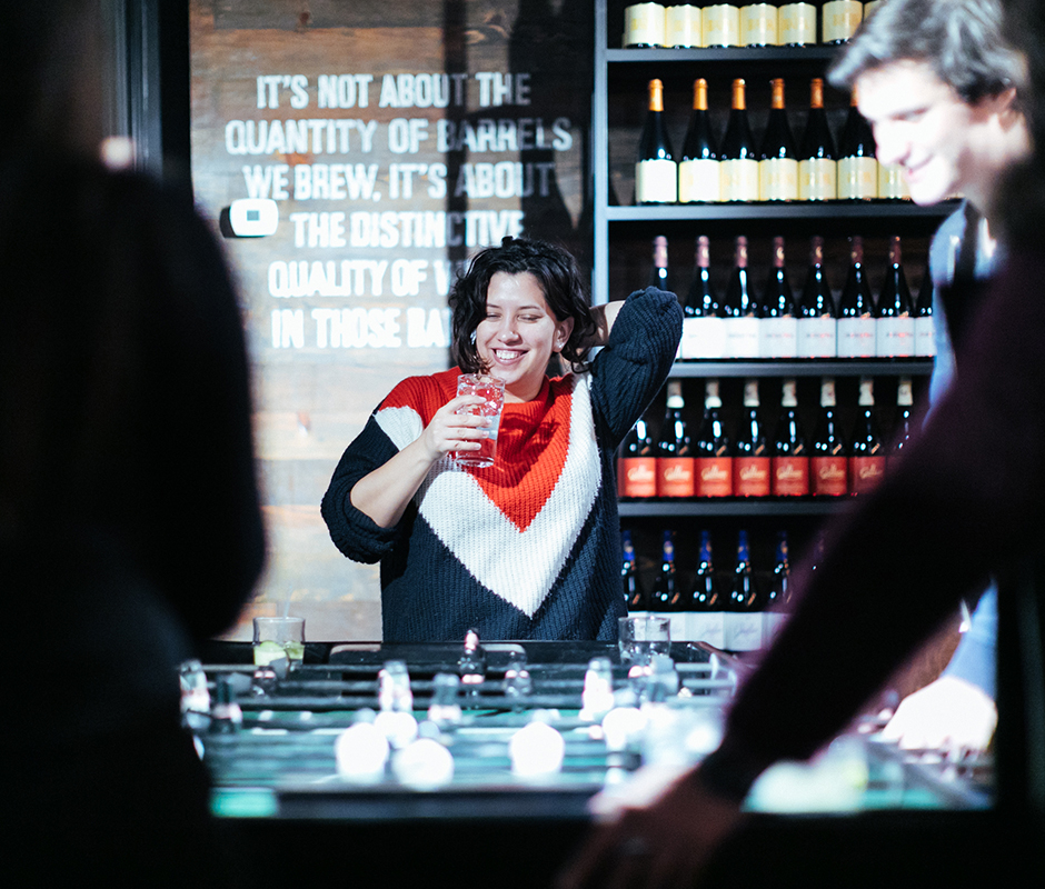 Woman with drink in hand playing bar games