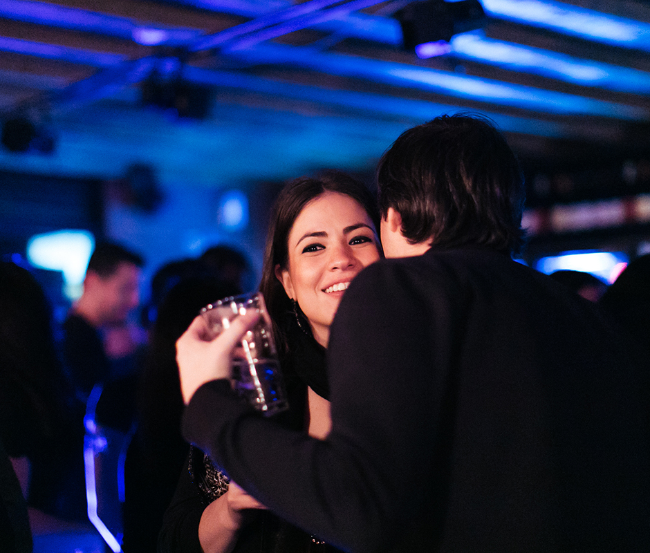 Man whispering to friend at noisy bar