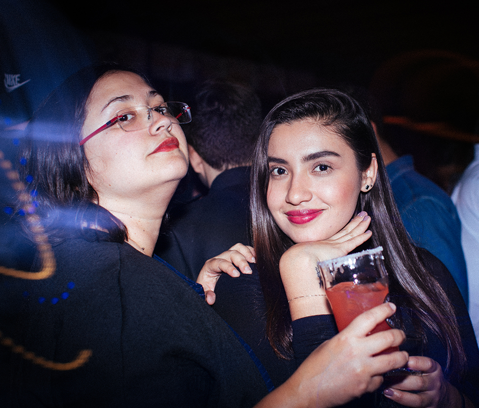 Two friends at bar posing for picture