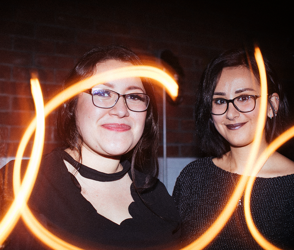 Two woman with glasses posing for picture with vintage effect
