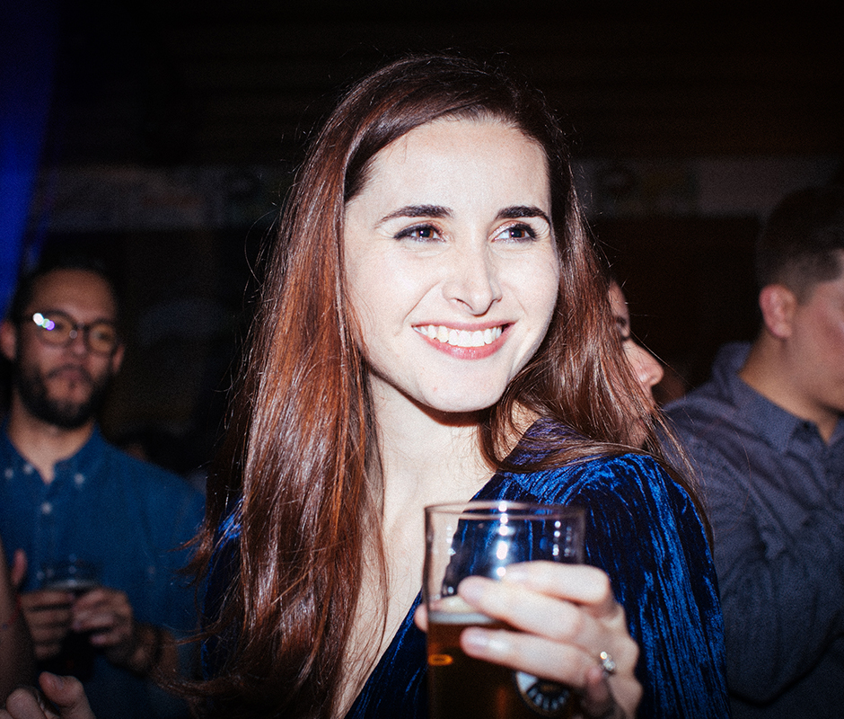 Woman with drink in hand smiling