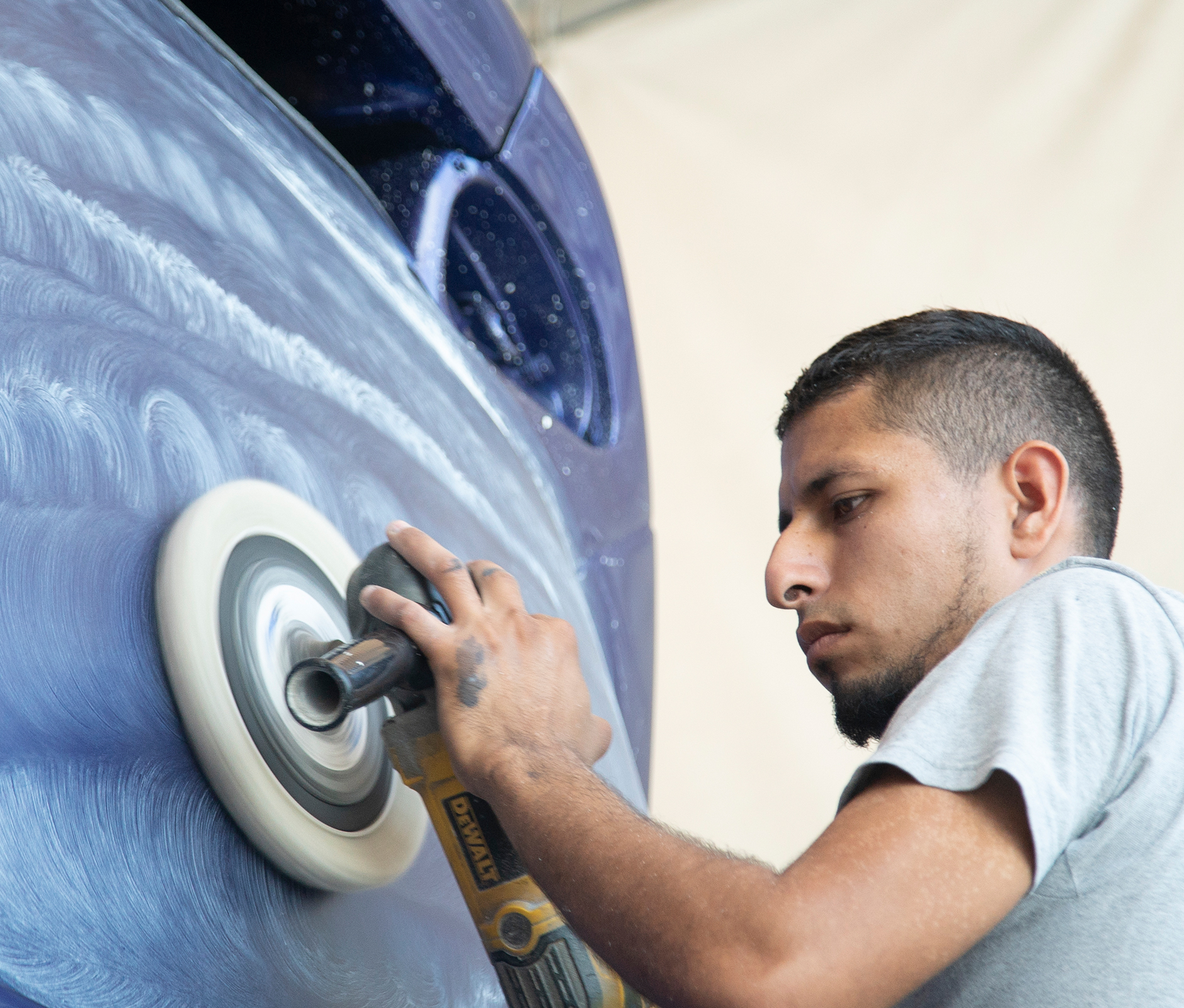 Man polishing bus paint job