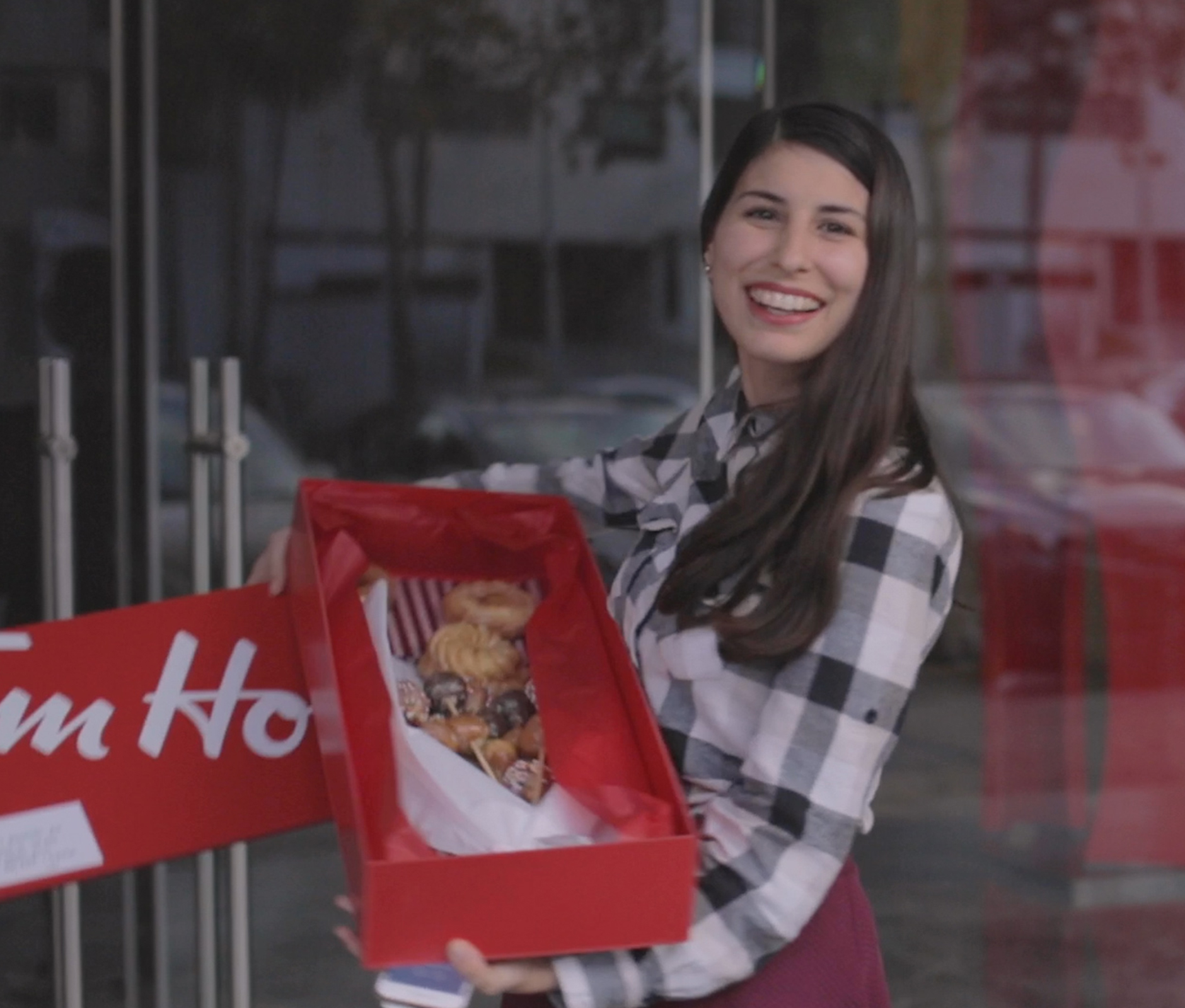 Women smiling with her delivery box from Tim Hortons