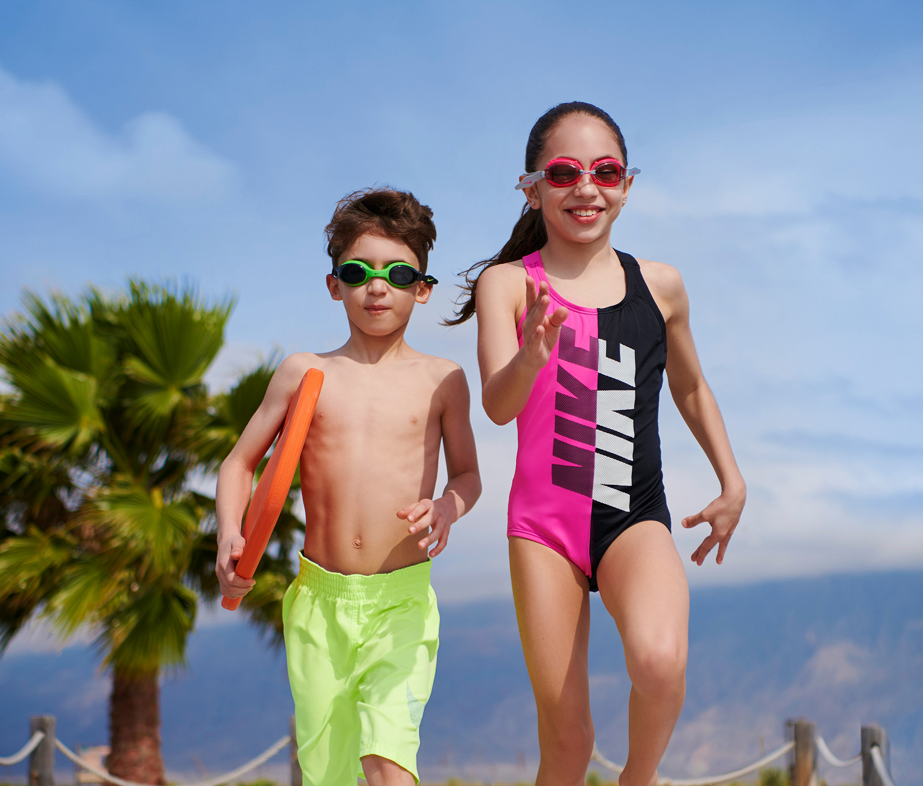 Kids with goggle and swimsuit running to the ocean 