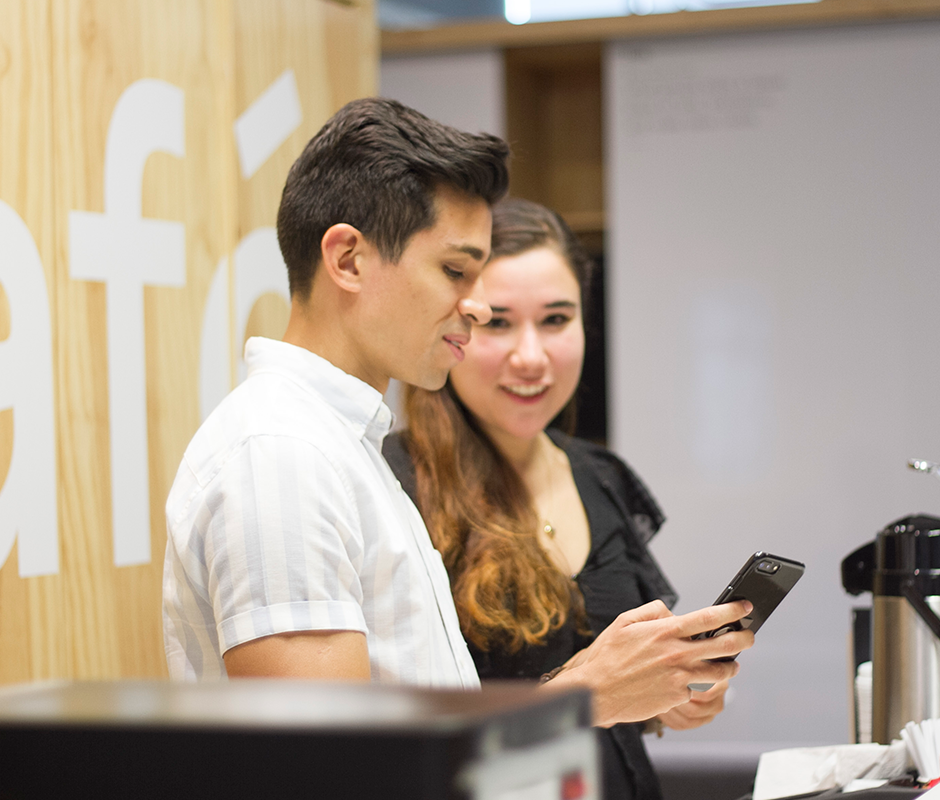 Man showing something in his phone to a friend