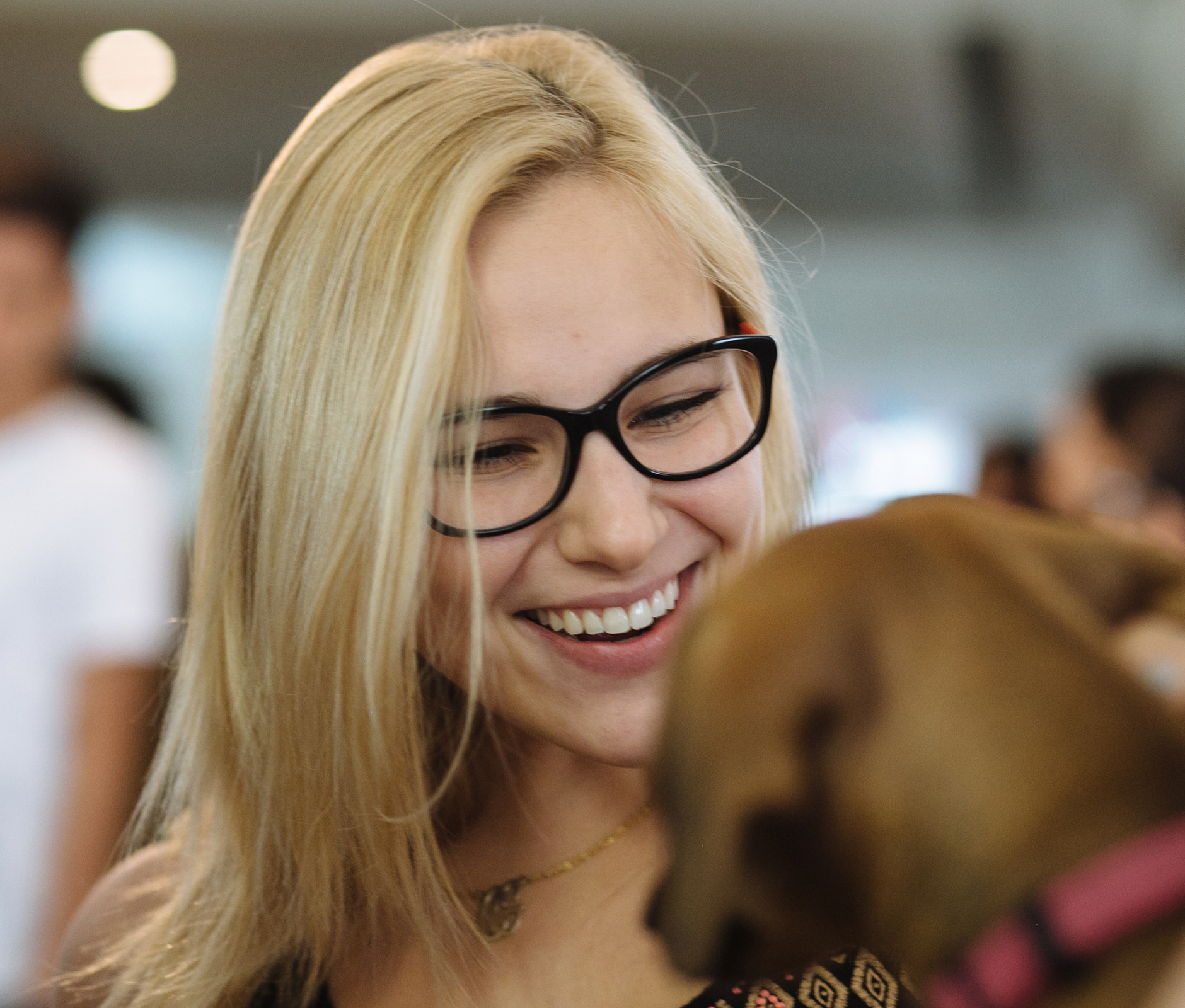 Woman with glasses smiling at a dog